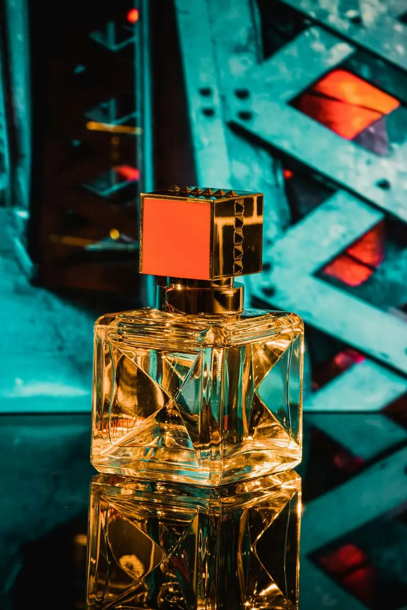 An elegant crystal-cut perfume bottle in gold light