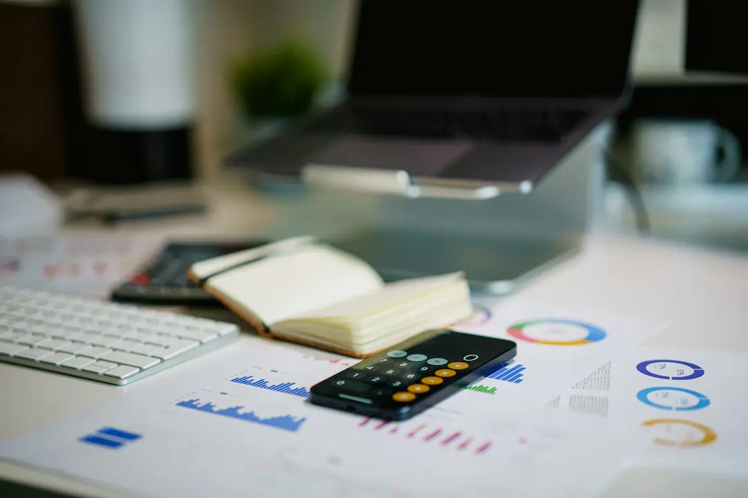 A calculator and financial charts on a desk